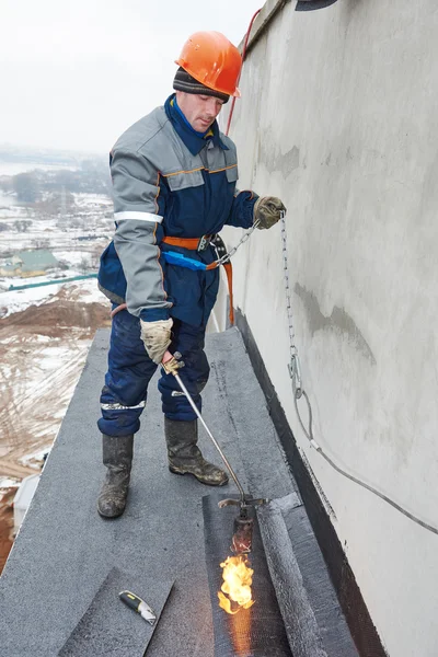 Flat roof installation. Workers melting bitumen roofing felt — Stock Photo, Image