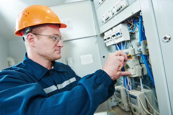 Electrician with screwdriver repair switching electric actuator in fuse box — Stock Photo, Image