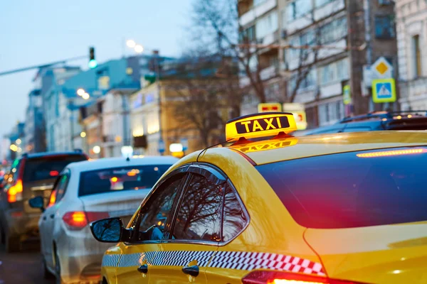 Taxi sign on car at evening in the city street — Stock Photo, Image