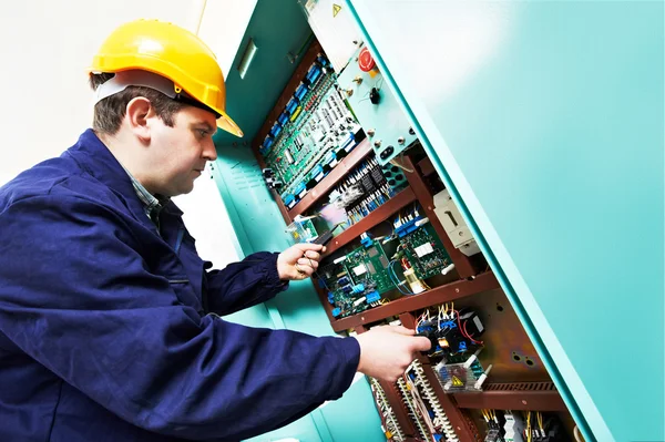 Adult electrician builder engineer worker testing electronics in switch board — Stock Photo, Image