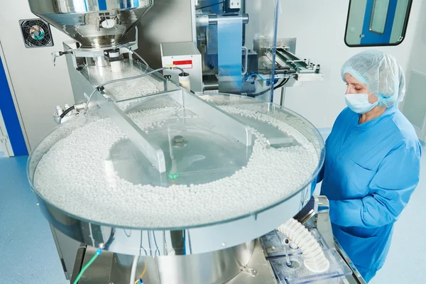 Pharmaceutics. Pharmaceutical worker operates tablet blister packaging machine — Stock Photo, Image