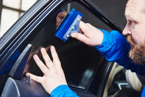 Teñido de coche. Técnico mecánico de automóviles aplicando lámina — Foto de Stock