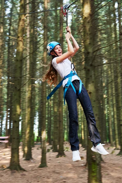 Mädchen reitet Seilbahn im Wald-Abenteuer-Hochseilpark — Stockfoto