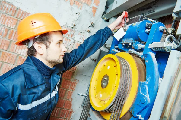 Machinist worker adjusting elevator mechanism of lift — Stock Photo, Image