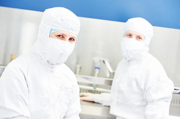 Trabalhadores com uniforme de protecção em laboratório — Fotografia de Stock