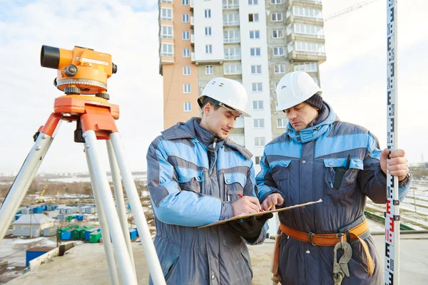 Surveyor workers with level at construction site — Stock Photo, Image