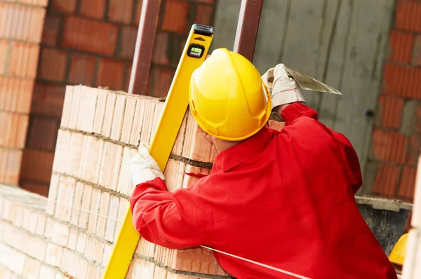 Muratore al lavoro con mattoni rossi — Foto Stock