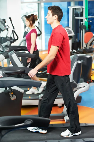 Homem positivo em pernas máquina de exercícios — Fotografia de Stock