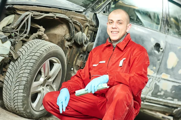 Automonteur bij auto lichaam reparatiewerkzaamheden — Stockfoto