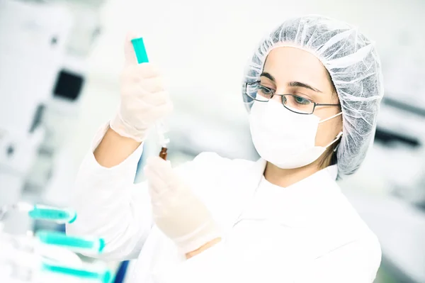 Scientific researcher pouring flask with liquid solution — Stock Photo, Image