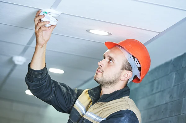 Trabajador instalando detector de humo en el techo — Foto de Stock