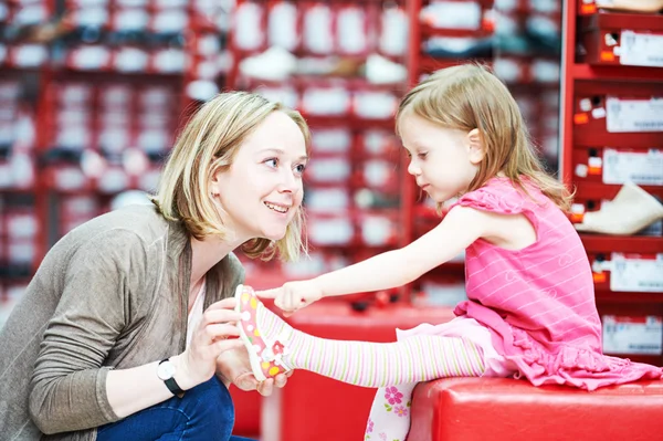 Familjen shopping väljer barnet skor skor — Stockfoto