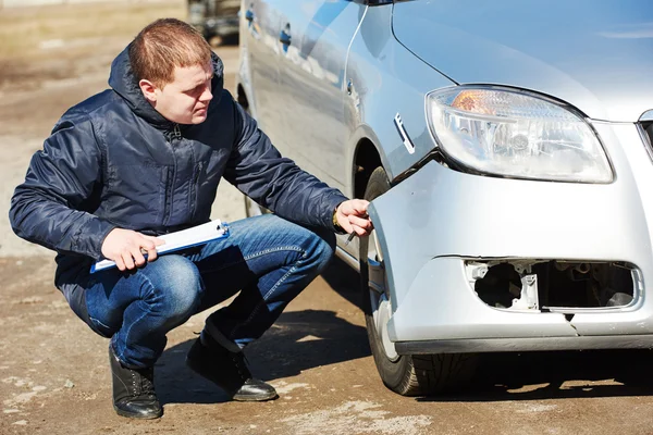 Insurance agent recording car damage on claim form — Stock Photo, Image