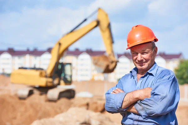 Ekskavatör yükleyici önünde inşaat işçisi sürücü — Stok fotoğraf