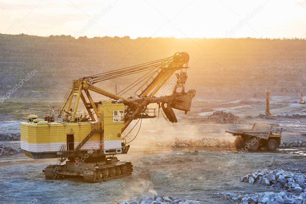 Mining. excavator and dump truck in granite or iron opencast