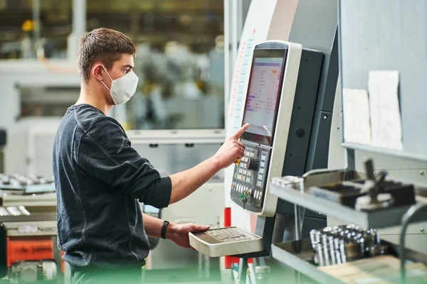 Βιομηχανικός εργαζόμενος που λειτουργεί cnc μηχανή στην προστατευτική μάσκα στη βιομηχανία κατεργασίας μετάλλων — Φωτογραφία Αρχείου
