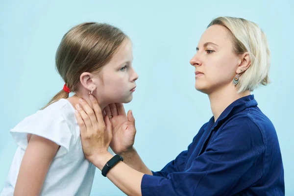 Pediyatrist kadın doktor küçük kızın boğazına dokunuyor. — Stok fotoğraf