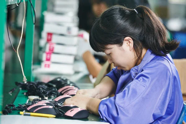 chinese female worker in assembling electronic device on factory