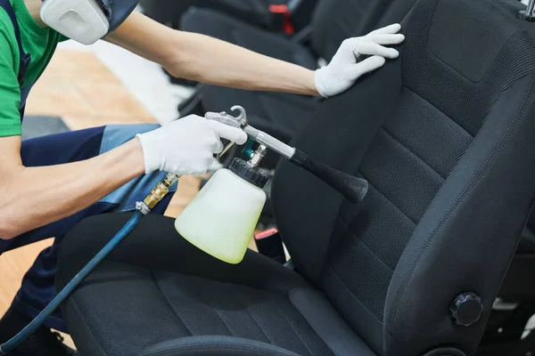 Carro detalhando. limpeza de estofos de assento de pano com pistola de limpeza de pulso de ar de alta pressão — Fotografia de Stock