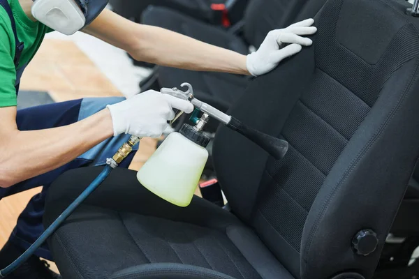 Dettagli dell'auto. pulizia della tappezzeria del sedile in panno con pistola per la pulizia ad aria ad alta pressione — Foto Stock