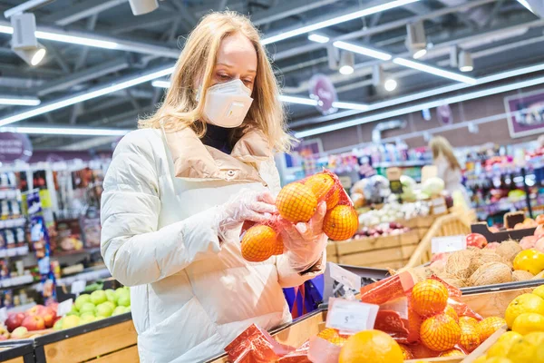 Donna in maschera e guanti protettivi acquisto di cibo in negozio a coronavirus epidemia — Foto Stock