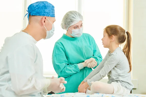Mužský chirurg a ošetřovatelka vysvětlují operaci dětskému pacientovi — Stock fotografie