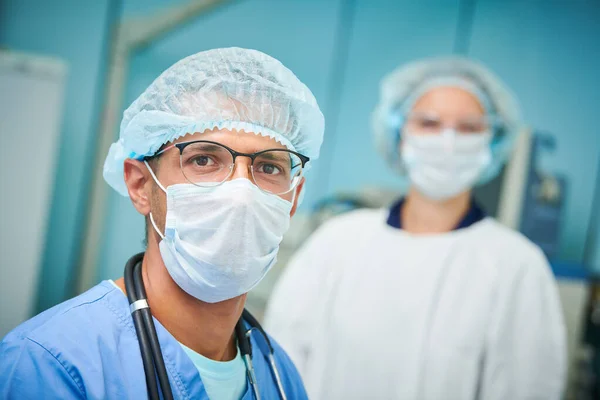 Portret zespołu chirurgów w szpitalu. Kolorowy mężczyzna i biała kobieta lekarze — Zdjęcie stockowe