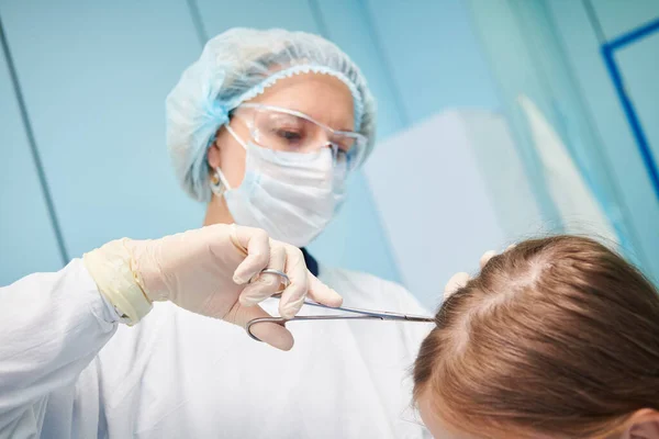 Παιδίατρος γυναίκα γιατρός eximines του κεφαλιού κοριτσάκι — Φωτογραφία Αρχείου