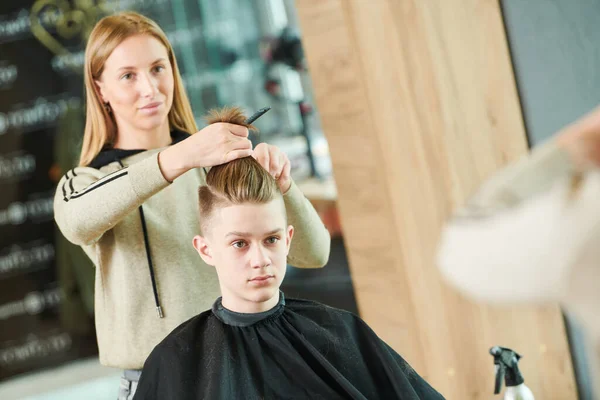 Corte de cabelo do jovem. Cabeleireiro na barbearia — Fotografia de Stock