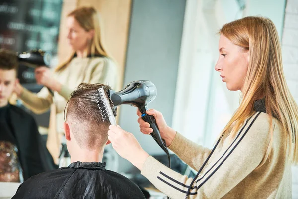 Corte de cabelo do jovem. Cabeleireiro na barbearia — Fotografia de Stock