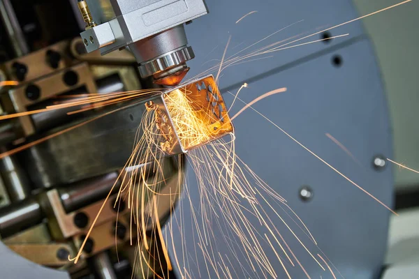 Corte a laser de tubos de metal com faíscas na máquina a laser de tubos — Fotografia de Stock
