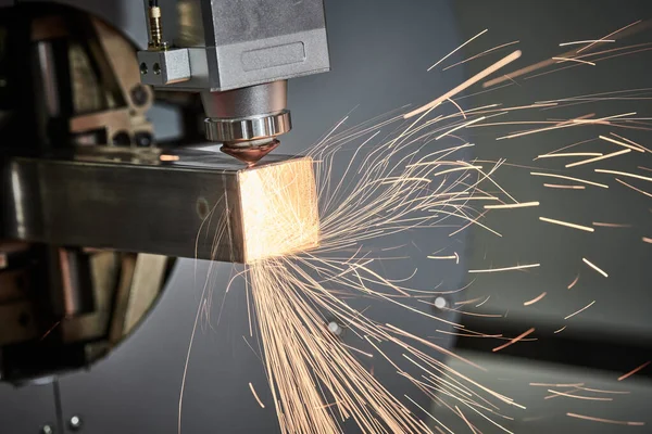 Corte a laser de tubos de metal com faíscas na máquina a laser de tubos — Fotografia de Stock