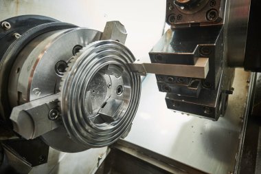 Metal endüstrisindeki CNC makinesini çalıştırmak. Kesme aracı metal detay yüzünde spiral oyuk oluşturur