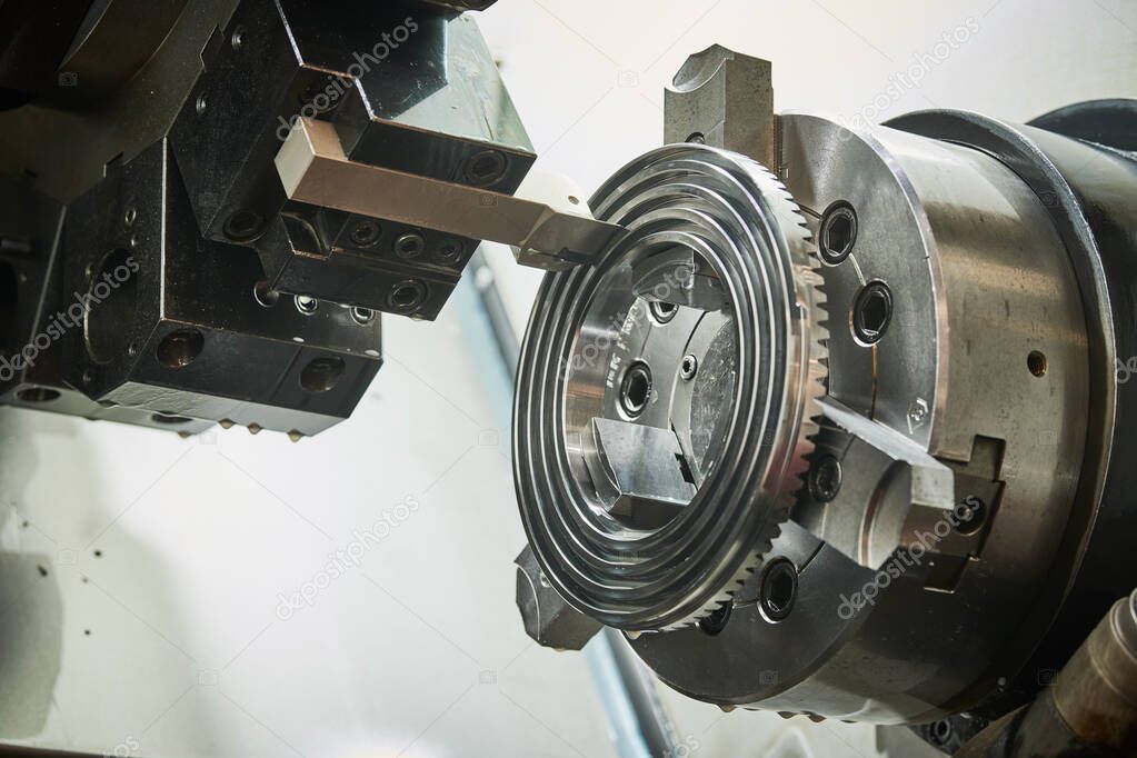 turning operation on cnc machine in metalworking industry. Cutting tool makes spiral groove on metal detail face