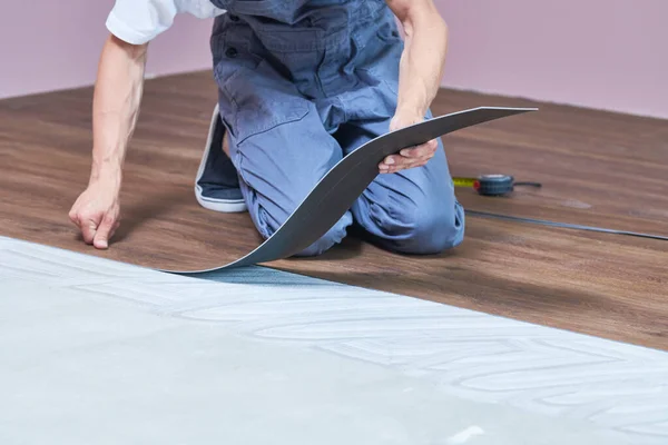 Worker joining vinyl floor covering at home renovation — Stock Photo, Image