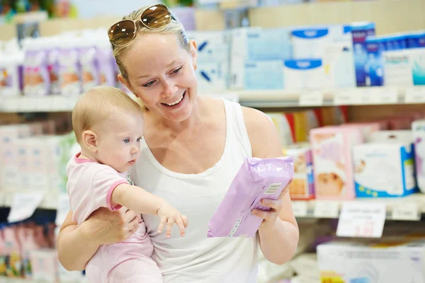Woman with baby in shop — Stock Photo, Image