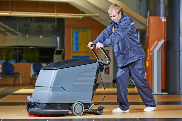 Arbeiter putzt Fußboden mit Maschine — Stockfoto