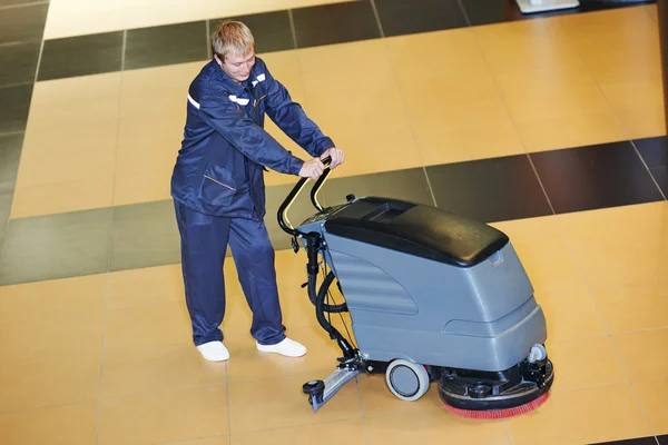 Worker cleaning floor with machine — Stock Photo, Image