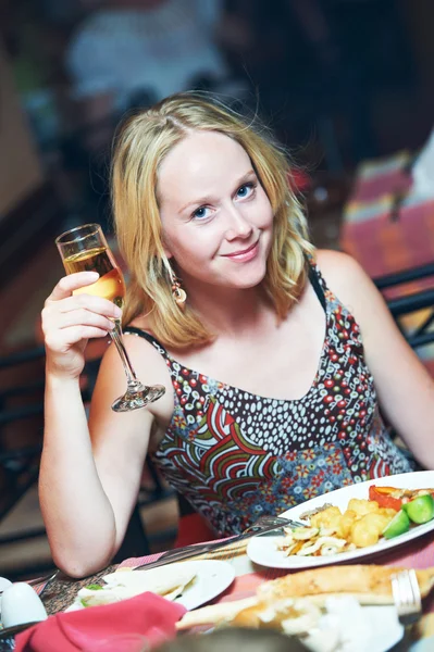 Žena se sklenkou vína v restauraci — Stock fotografie