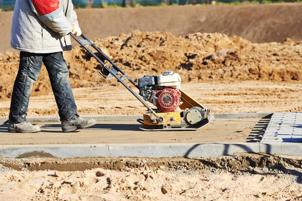 Trabalhador com compactador de vibração — Fotografia de Stock