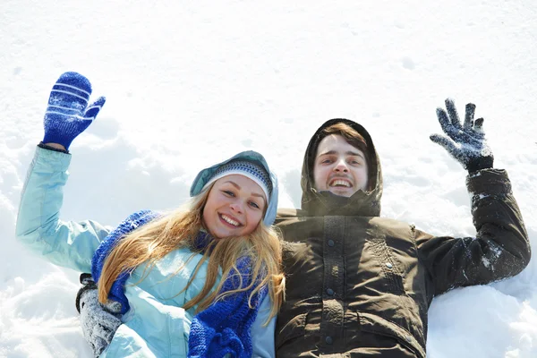 Young happy lying on snow in winter — Stock Photo, Image