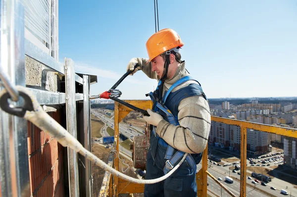 Arbetstagaren byggare på fasad kakel installation — Stockfoto