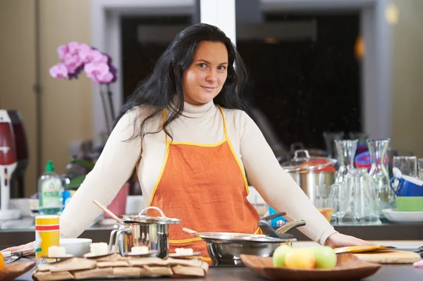 Lachende huisvrouw in haar keuken koken — Stockfoto