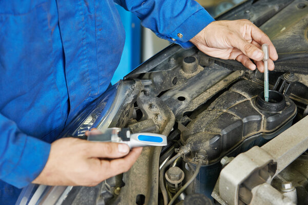 auto mechanic tests car antifreeze liquid