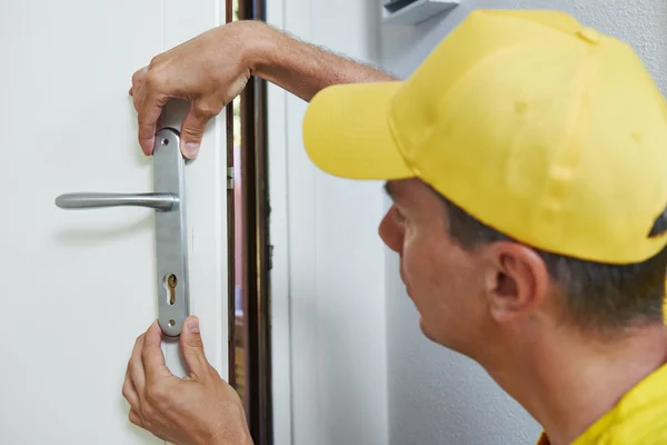 Carpintero en la instalación de cerradura de puerta — Foto de Stock