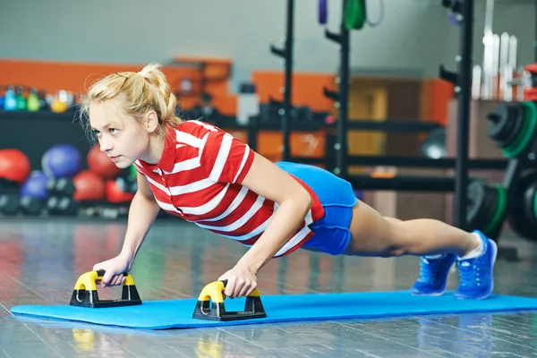 Mulher empurrando para cima no ginásio fitness — Fotografia de Stock