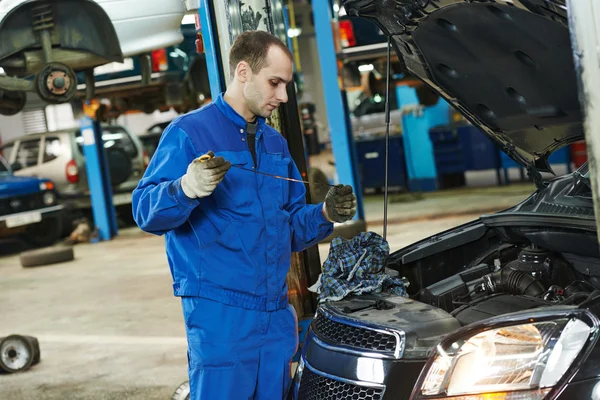 Mechanic checking oil level in automobile — Stock Photo, Image