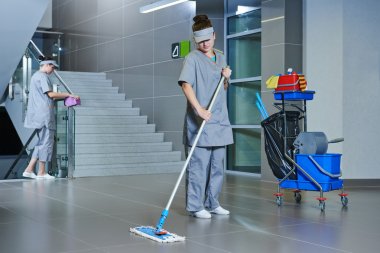 worker cleaning floor with machine clipart