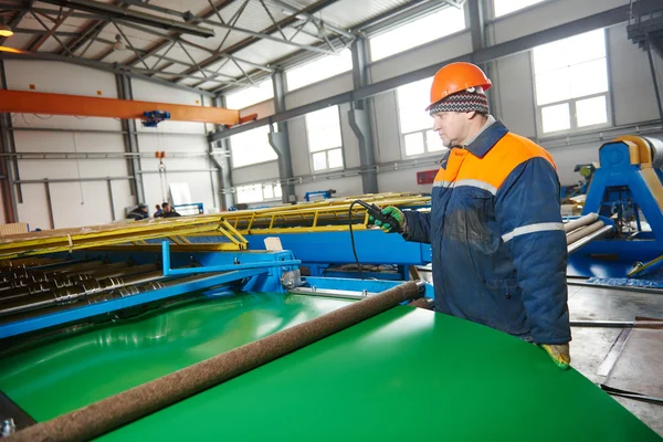 Worker at metal sheet profiling factory — Stock Photo, Image