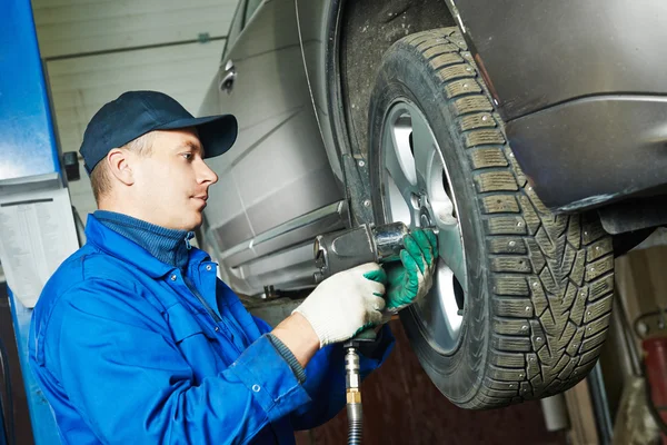 Auto mechanik šroubovací kola automobilu klíčem — Stock fotografie